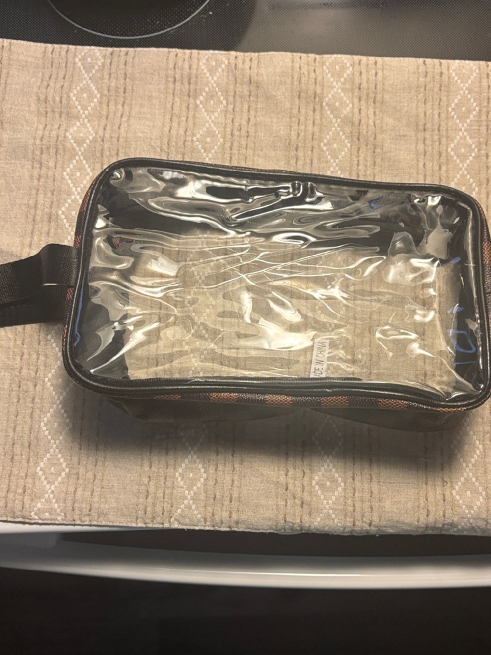 Clear Travel Toiletry Bag with Black Trim and Checkered Pattern on sides